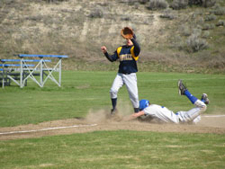 Tonasket senior Wade DeTillian slides safely onto third base after stealing while Oroville third-baseman Nicky Perez waits for the ball from catcher Brody Naysnerski during the first game of Tonasket’s doubleheader against the Hornets on Wednesday, Apri