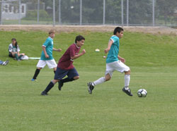 1323a A Tonasket U15 soccer player on the Spectacle Lake Resort team kicks the ball down the field as an opponent from the Oroville Discount Fireworks team pursues him during the Youth Soccer Tournament on Saturday, May 22. The Spectacle Lake Resort team won th