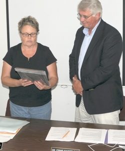 School Director Tedi Lynn Fletcher, chairwoman of the school board, presents a plaque to Dr. Ernie Bartelson commemorating his 13 years as superintendent for the Oroville School District. He was also presented with gifts from the board, including a “Str