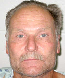 James Joel Landis, still in hospital garb after being released from Central Washington Hospital, in his booking photo. Landis has been charged with Attempted first degree Murder, Assault with a Deadly Weapon and Harassment Threats to Kill.