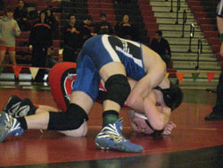 Tonasket senior Peter Williams curls over Omak’s Sammy Trudeaux in an effort to roll him to his back during the semi-final round of the 140 pound weight class at the District 6 wrestling tournament in Omak on Saturday, Feb. 5. Williams lost the round 5-