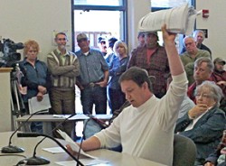 Photo by Jennifer MarshallJon Wyss, chairman ofthe Okanogan County Coalition for Property Rights, holds aloft a 500-pagedocument from Futu