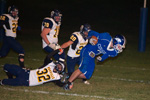 The Hornets' Angel Camacho hangs onto the ankle of Warden running back Adam Hansen during Oroville's 34-2 loss to the Cougars.