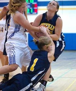 Tonasket's Alicia Edwards and Oroville's Kelsey Hughes - with a little help from teammate Briana Moralez - grapple for possession during Saturday's Tonasket victory.