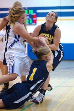 2216a Tonasket's Alicia Edwards and Oroville's Kelsey Hughes - with a little help from teammate Briana Moralez - grapple for possession during Saturday's Tonasket victory.