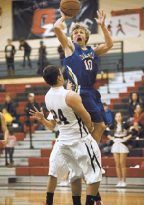 Photo by Brent Baker — John Stedtfeld tries to get to the hoop against Omak on Jan. 17, but picks up a charging call for hits efforts.