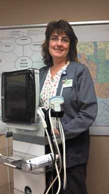 2406a North Valley Hospital Director of Ancillary Services Noreen Olma shows of the hospital's new portable ultrasound unit at the NVH board of commissioners' meeting on Thursday, Feb. 23. photo by Brent Baker