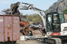 Chris Celli loads scrap metal into a container that will be trucked to the coast and loaded on ships for reuse elsewhere. Celli buys several types of scrap metal at his CNC BuyBack Center, just south of Oroville on SR97. Photo by Gary DeVon