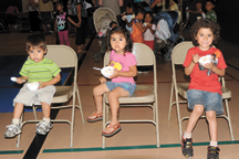 2762a Christopher Castillo, age two, Keyli Castillo, age three and Kevin Castillo, age five, enjoy ice cream last Monday evening during the Open House at Oroville Elementary School. They were among the many students served ice cream and toppings in the gym by s