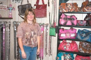 Karla Stucker shows off some of the "bling" in her shop located inside II Sisters Video in Tonasket. Brent Baker/staff photo