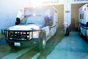 Bob Garrison (left) and General Manager of Wenatchee-based Lifeline Ambulance, Inc., give Oroville's ambulance  a quick cleaning on Friday morning. Gary DeVon/staff photo 