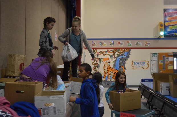 Food Drive movers and shakers: Tonasket Elementary School ASB members move pounds of food from the weight station onto the stage where it will be organized and further inventoried for distribution. Pictured clockwise, from top left are Jordyn O’Conner, Isabel Steinshouer, Paityn Thrasher, Roxanna Reynoso, Tanner Tompkins and Yaretzi Dominguez. 