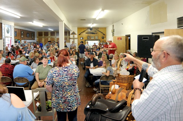 Gary DeVon/staff photo Auctioneer Ken Neal works the crowd at a benefit for Jack and Theresa Nelson last Saturday evening at the American Legion Hall. Jack Nelson has a rare infection that is attacking his kidneys and liver and the benefit was to help the couple with medical expenses. The dinner, live and silent auction raised $33,411, according to Neal and the Friends Account at the bank has raised $8,050. Nelson spoke with the crowd via a video call on Facetime from his hospital bed in Spokane. “There wasn’t a dry eye in the house,” said Neal. The auctioneer added that there were some very generous donors and bidders for the auction. Jack Hughes, he said, won a shotgun for $1,000 and donated it right back where it raised another $750. In the opening auction for three cheesecakes the winning bid was also $1,000, he said. “Probably 10 of the 83 live auction items we sold were redonated and resold,” said Neal.