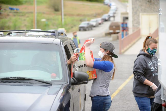 Gary DeVon/staff photos Potatoes were delivered in a drive-thru with volunteers in masks handing the spuds to the drivers.