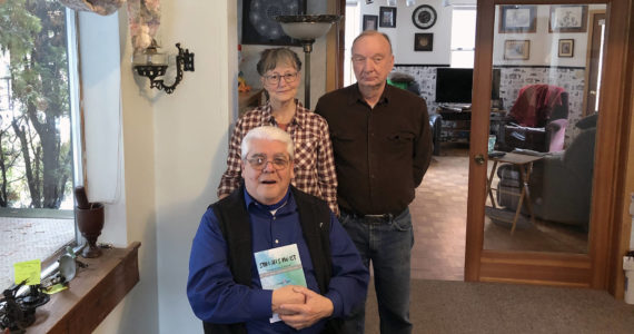 Gary DeVon / staff photo
Arnie Marchand with his new book “What is Your Name?” and his publishers Kay and Mike Sibley at their home in Oroville.