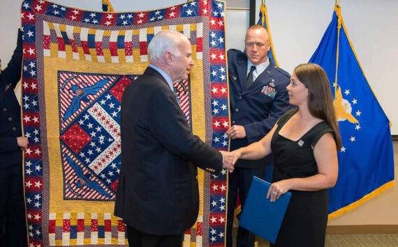 The late U.S. Senator John McCain, USN Retired, being awarded his Quilt of Valor by Michelle Nelson, QOVF Board of Directors. An as yet unamed Quilts of Valor group is forming in the Tonasket area. QOV photo
