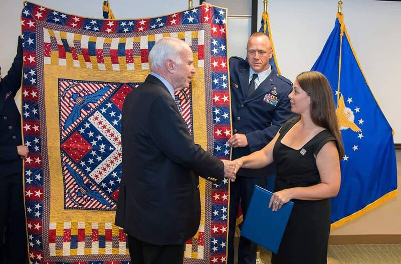 The late U.S. Senator John McCain, USN Retired, being awarded his Quilt of Valor by Michelle Nelson, QOVF Board of Directors. An as yet unamed Quilts of Valor group is forming in the Tonasket area. QOV photo