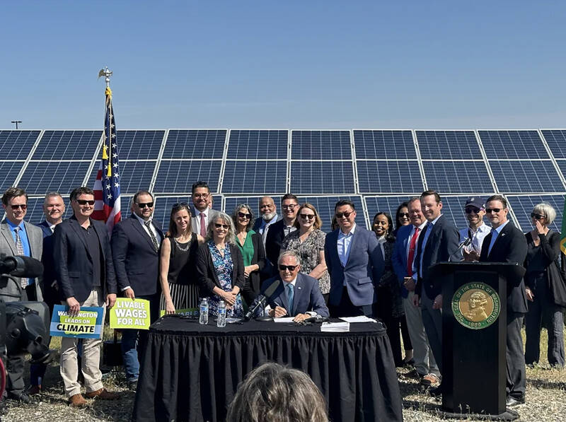 Gov. Jay Inslee, legislators, and clean energy advocates celebrate the signing of seven bills strengthening Washington’s implementation of clean energy policies. Image courtesy of Gov. Inslee’s Medium page