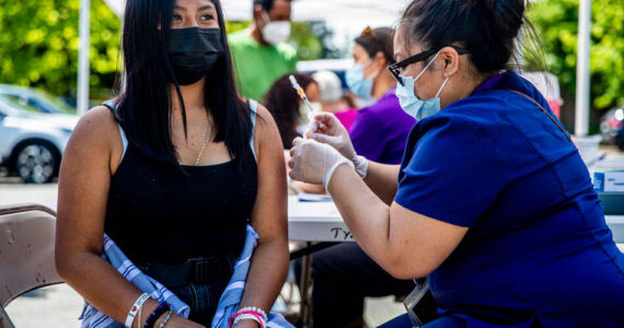 Jacqueline Alvarado, 14, receives a vaccine during a clinic for students and families at Tyee High School on June 4, 2021. Alvarado came to the clinic with her aunt, who also got vaccinated, and her father, sibling and cousins. (Dorothy Edwards/Crosscut)