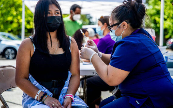Jacqueline Alvarado, 14, receives a vaccine during a clinic for students and families at Tyee High School on June 4, 2021. Alvarado came to the clinic with her aunt, who also got vaccinated, and her father, sibling and cousins. (Dorothy Edwards/Crosscut)