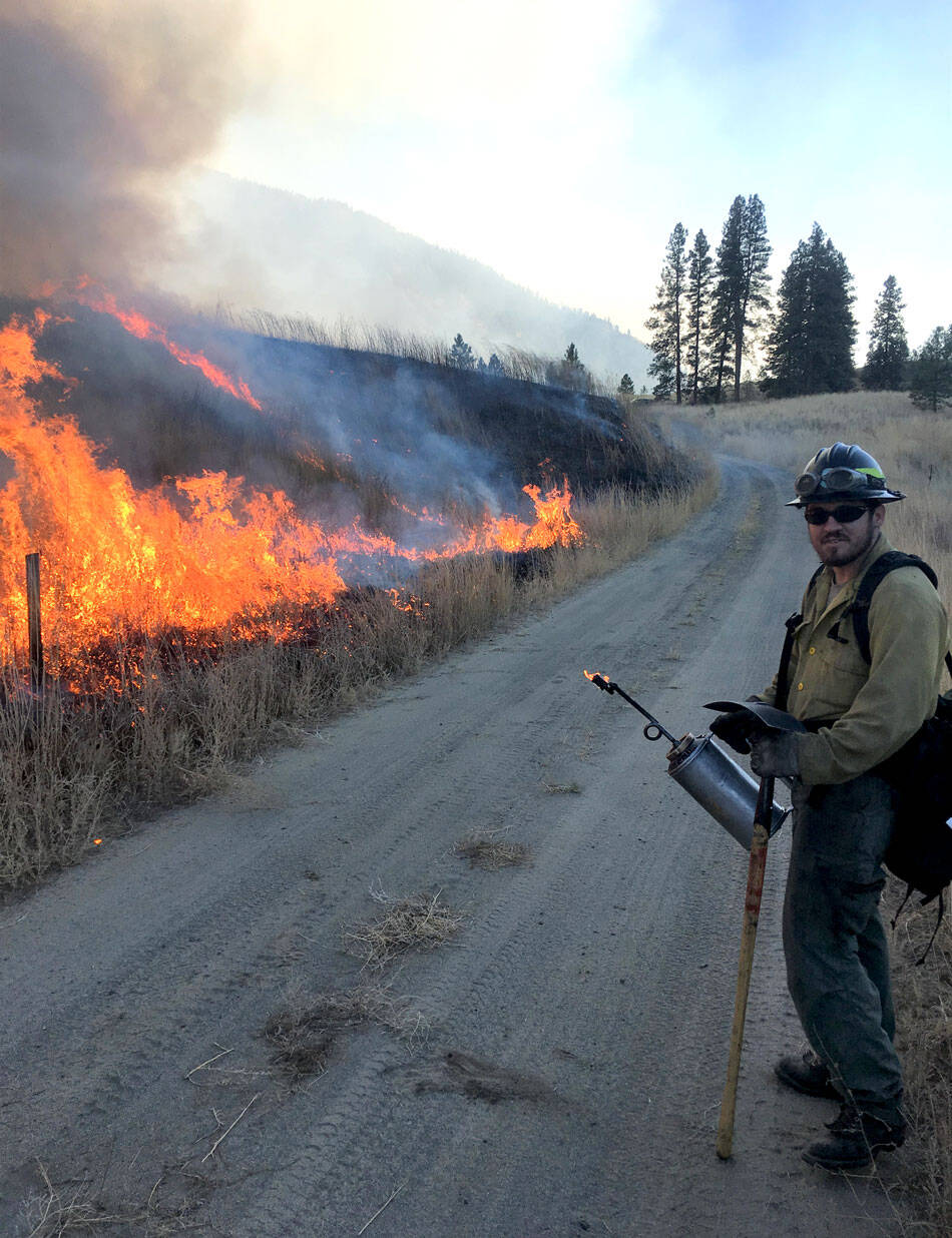 A prescribed burn is monitored by a WDFW crew member.