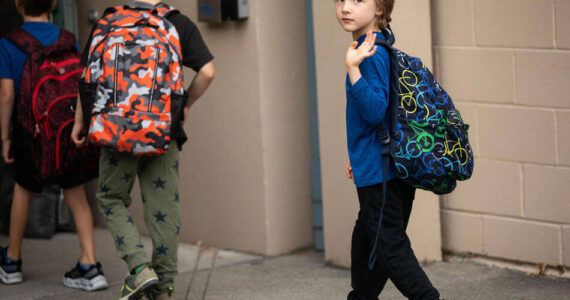 Orion Muller waves goodbye to his mother on Wednesday, Sept. 14, 2022, his first day of kindergarten at Greenwood Elementary. Washington is the only state that doesn’t require kids to start school until age 8. (Amanda Snyder/Crosscut)