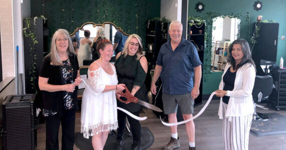 Eva Brenon and Tasha Gordon use the big scissors to cut the ribbon at their salon in a ceremony held by the Oroville Chamber of Commerce. Also pictured are Oroville Chamber Board Member Peggy Shaw and Chamber President Rocky DeVon and Chamber Secretary Laura Curdie. <em>Gary DeVon/staff photo</em>