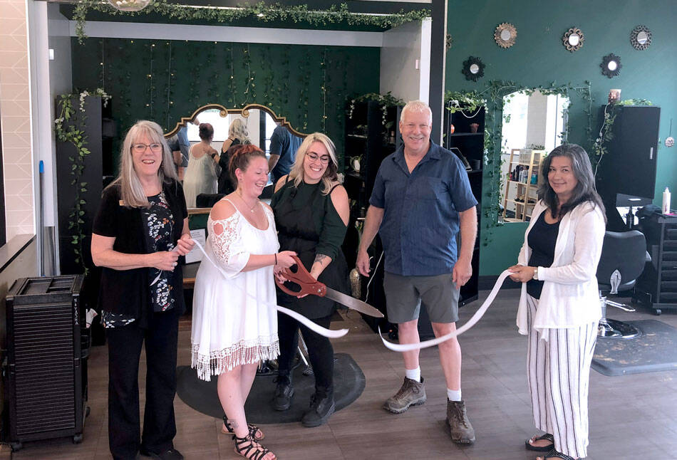Eva Brenon and Tasha Gordon use the big scissors to cut the ribbon at their salon in a ceremony held by the Oroville Chamber of Commerce. Also pictured are Oroville Chamber Board Member Peggy Shaw and Chamber President Rocky DeVon and Chamber Secretary Laura Curdie. <em>Gary DeVon/staff photo</em>
