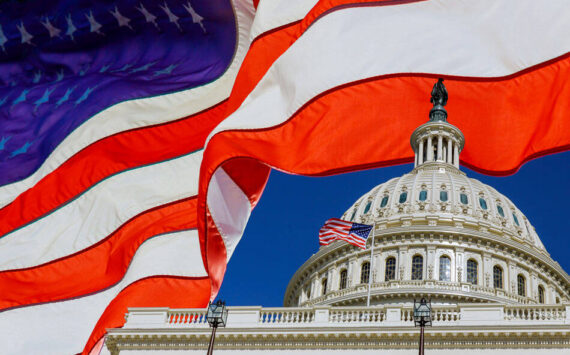 A panoramic view United States Capitol Building at Washington, DC, USA with American flag. Adobe Stock Photo