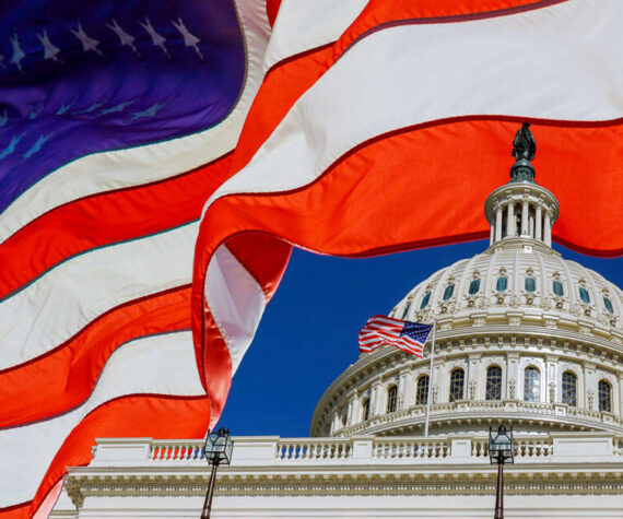 A panoramic view United States Capitol Building at Washington, DC, USA with American flag. Adobe Stock Photo