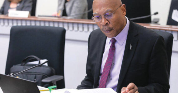 Sen. John Lovick studies a proposal at his desk on the floor of the Senate. Photo courtesy of Senate Democrats