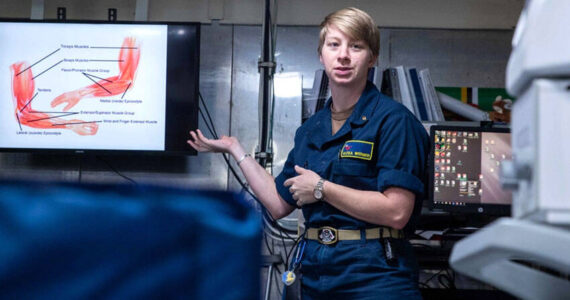 Lt. Alexa Werner, from Oroville, Washington, the ship’s physical therapist aboard Nimitz-class aircraft carrier USS George Washington (CVN 73), displays a muscle diagram during a sick call evaluation training in main medical while underway in the Philippine Sea, Nov. 20, 2024. George Washington is 7th Fleet’s premier forward-deployed aircraft carrier, a long-standing symbol of the United States’ commitment to maintaining a free and open Indo-Pacific region, while operating alongside Allies and partners across the U.S. Navy’s largest numbered fleet. (U.S. Navy photo by Mass Communication Specialist 3rd Class Johnathan M. Meighan)