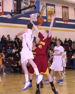 Photo by Terry MillsSenior Austin Olma of Tonasket tries to make a shot from under the hoop in Tonasket's game against Lake Roosevelt on Tuesday, Jan. 13. The Tigers lost, 66-39. Also shown are freshman Ty Egbert of Lake Roosevelt, senior Bryce Johnson (#
