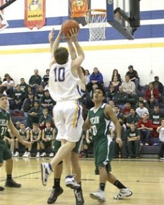 Tonasket senior Jeramy Dellinger jumps to make a shot over Joe Harris, a junior from Chelan, on Saturday, Jan. 31 Tonasket lost 81-42.Photo by Terry Mills