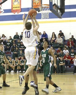 Tonasket senior Jeramy Dellinger jumps to make a shot over Joe Harris, a junior from Chelan, on Saturday, Jan. 31 Tonasket lost 81-42.Photo by Terry Mills