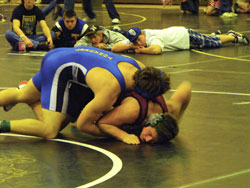 Josh Lofthus, Lee Leavell and Justin Dellinger watch as teammate Keegan McCormick wrestles Raleigh Beckstrom, a senior from Reardon High School, at the Royal Tournament on Tuesday, Dec. 29 in the 171 pound weight class. McCormick won the match despite Bec