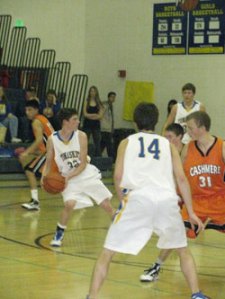 Tonasket junior Corbin Moser looks for an open teammate to pass the ball to during the Tigers’ home loss to Cashmere on Saturday, Jan. 9. Also shown is senior Blake Long (14) and junior Zach Neal. Photo by Emily Hanson