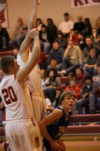 Tonasket sophomore John Stedtfeld crouches down to make a jump shot despite two tall Cascade defenders preparing to block the shot during Tonasket’s loss to Cascade on Saturday, Jan. 16. Photo by Ian Dunn
