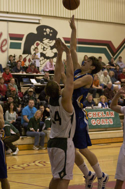 Tonasket junior Colton Ayers tries to make a shot over a Chelan Goat during the Tigers’ away game against Chelan on Saturday, Jan. 30. Photo by Les Bowen