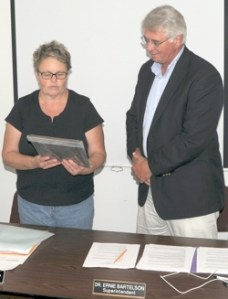 School Director Tedi Lynn Fletcher, chairwoman of the school board, presents a plaque to Dr. Ernie Bartelson commemorating his 13 years as superintendent for the Oroville School District. He was also presented with gifts from the board, including a “Str