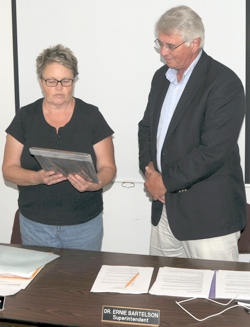School Director Tedi Lynn Fletcher, chairwoman of the school board, presents a plaque to Dr. Ernie Bartelson commemorating his 13 years as superintendent for the Oroville School District. He was also presented with gifts from the board, including a “Str