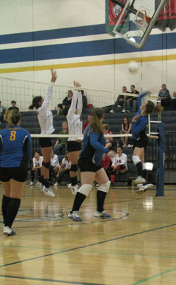 Tonasket senior Jessica Rhoads (right) slams the ball over the net against Omak while team mates senior Jayden Hawkins (middle) and junior Jessica Maier (left) prepare for the return hit during the Tigers’ home game against Omak on Saturday, Oct. 16. Ph