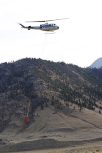 A helicopter, one of four dropping water on the fire on the hillside near the Nighthawk-Chopaka border crossing last Monday afternoon. Photo by Gary DeVon