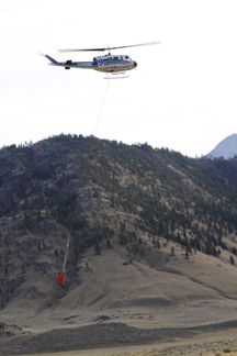 A helicopter, one of four dropping water on the fire on the hillside near the Nighthawk-Chopaka border crossing last Monday afternoon. Photo by Gary DeVon