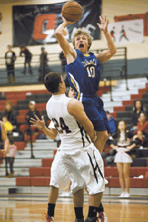 Photo by Brent Baker — John Stedtfeld tries to get to the hoop against Omak on Jan. 17, but picks up a charging call for hits efforts.