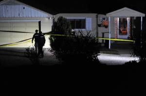 Okanogan County Sheriffs Deputies secure the residence of murder victim Siri Zosel last Saturday evening. Roy Rasmuseen, 70, Okanogan, was booked for first degree murder in what Sheriff Tony Hawley described as a fatal domestic dispute. <em>Gary DeVon/staff photo</em>