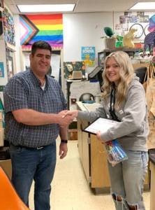 Okanogan Transit Authority General Manager Brent Timm congratualtes Avery Brown for her winning artwork at Okanogan High School. Submitted photo