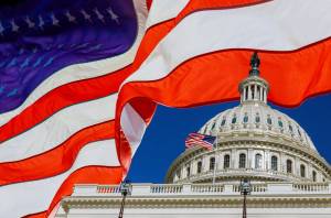 A panoramic view United States Capitol Building at Washington, DC, USA with American flag. Adobe Stock Photo